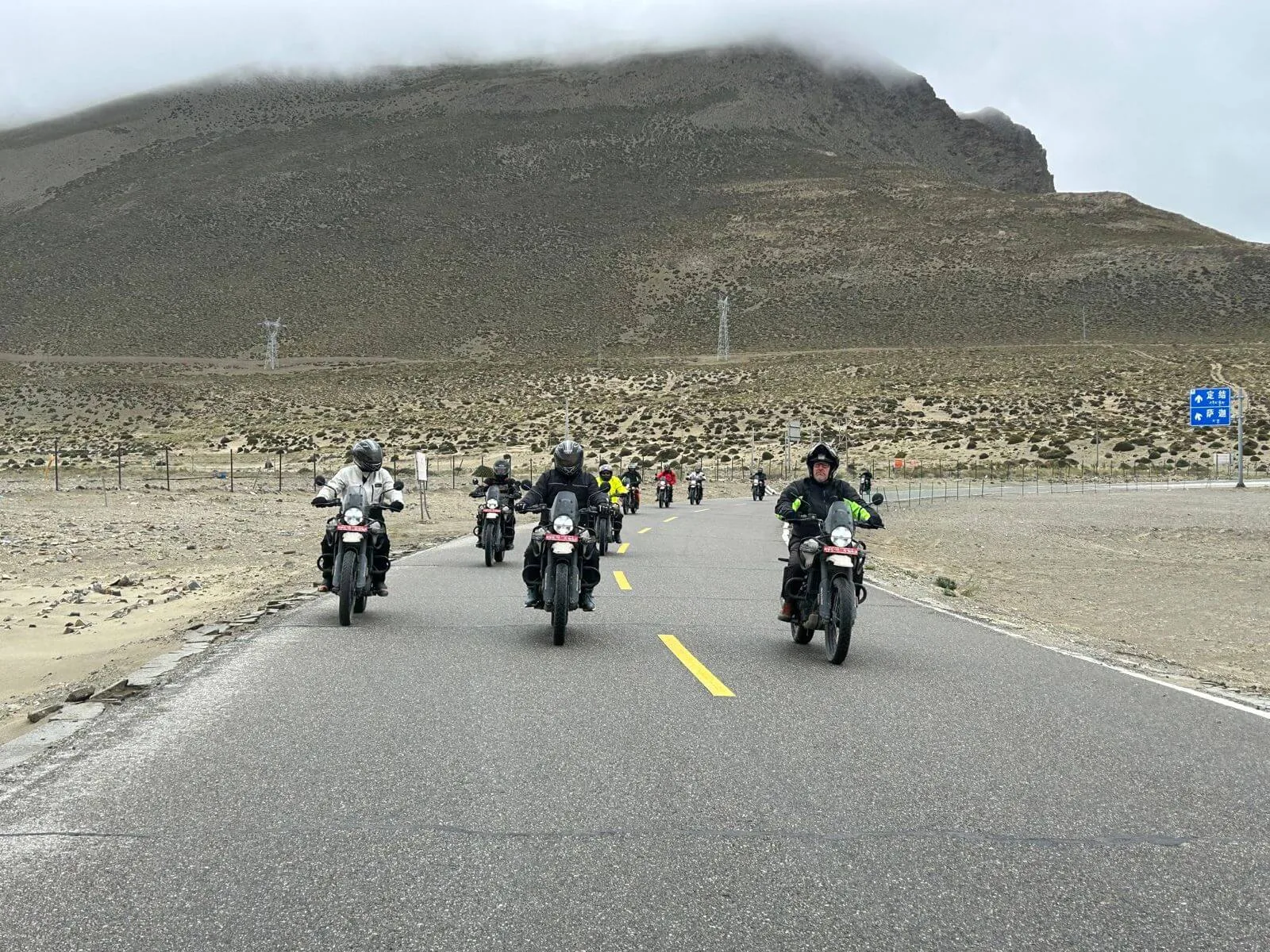 Groupe de motards avançant sur une route de haute altitude